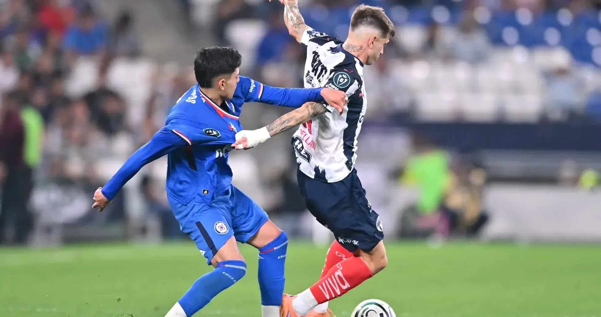 Monterrey player tackling Cruz Azul opponent Monterrey player tackling Cruz Azul opponent