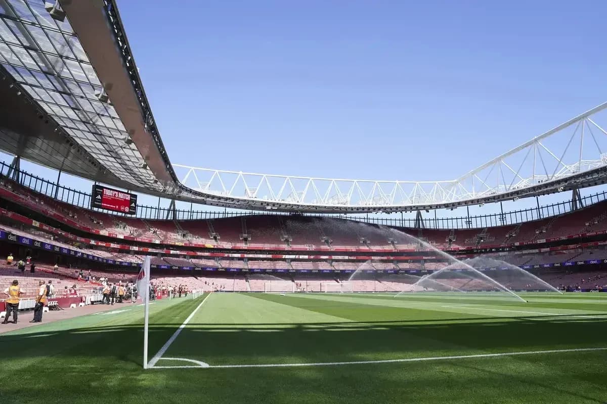 Empty stadium with sprinklers watering the pitch Empty stadium with sprinklers watering the pitch