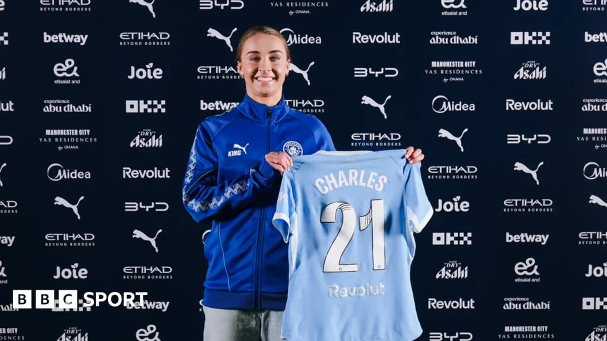 Player holding Manchester City jersey at press event Player holding Manchester City jersey at press event