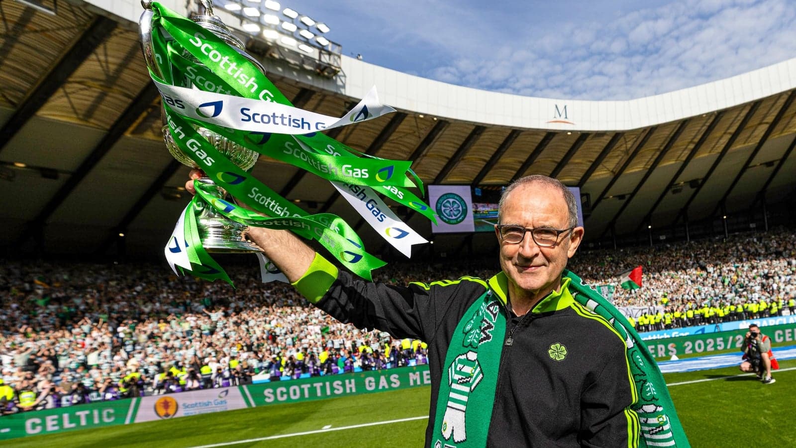 Man celebrating with trophy and Celtic scarf Man celebrating with trophy and Celtic scarf