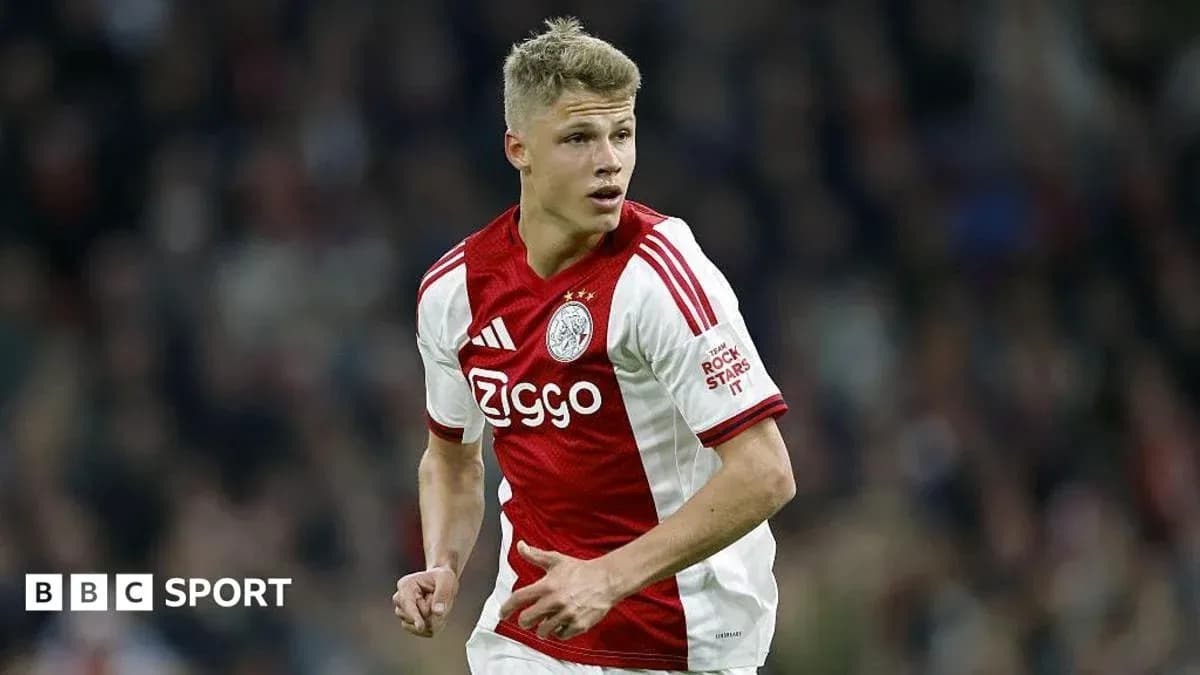 Player in Ajax jersey running on the field Player in Ajax jersey running on the field