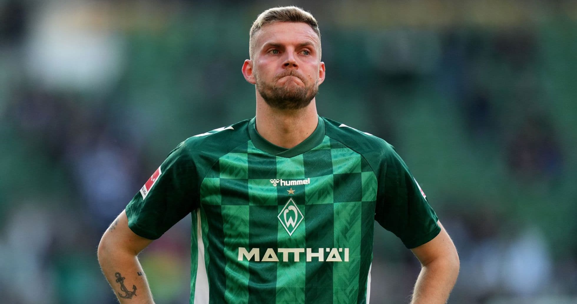 Player in green jersey standing on the field Player in green jersey standing on the field