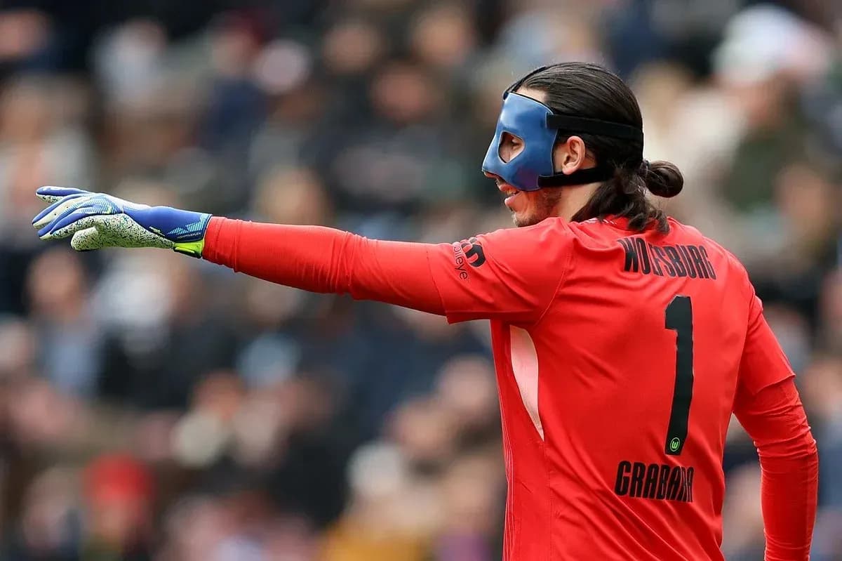 Goalkeeper in red jersey directing play on field Goalkeeper in red jersey directing play on field