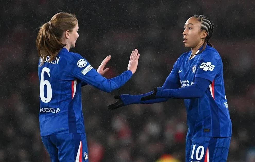 Two Chelsea players exchanging a high five on field Two Chelsea players exchanging a high five on field