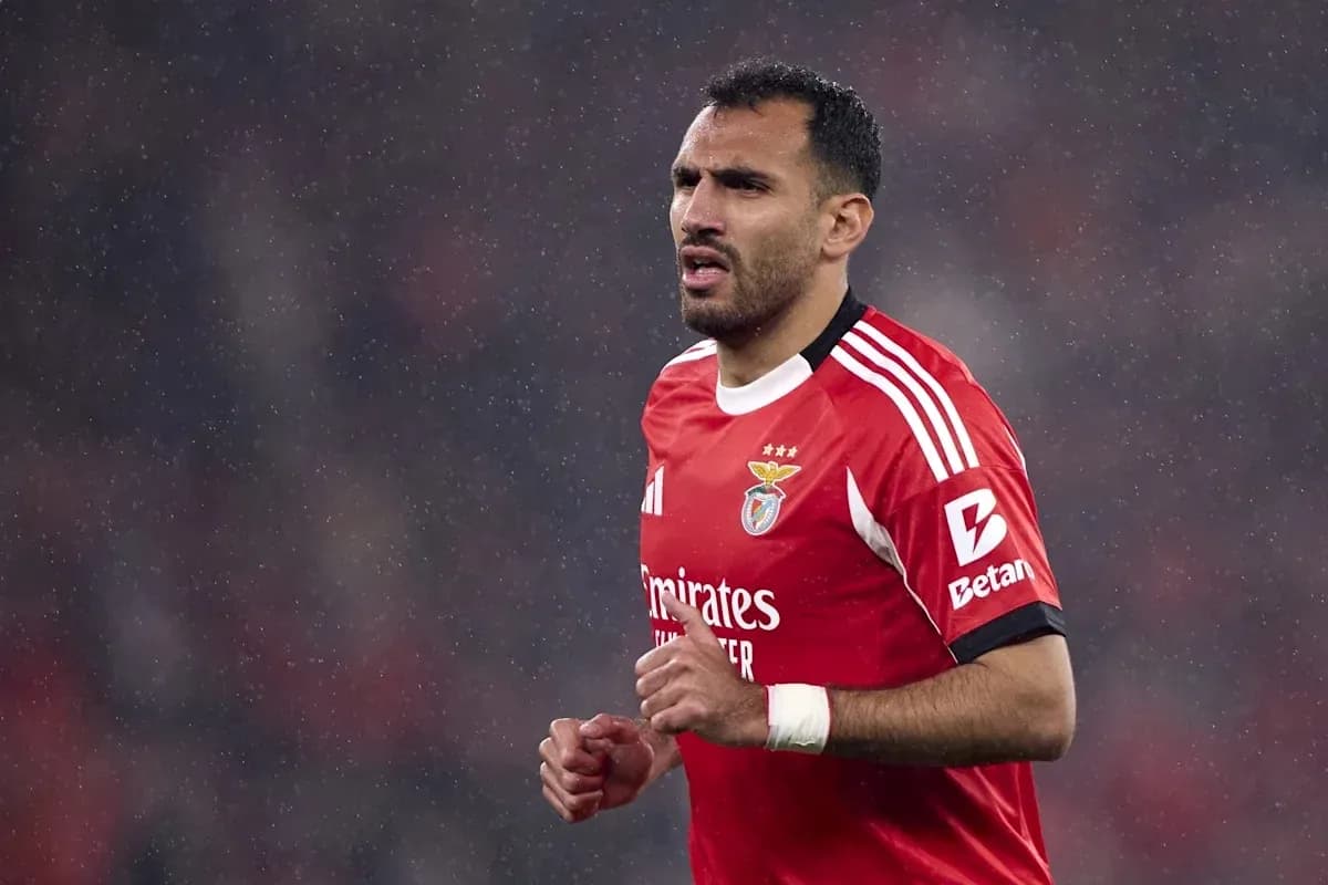 Benfica player running in rain during match Benfica player running in rain during match