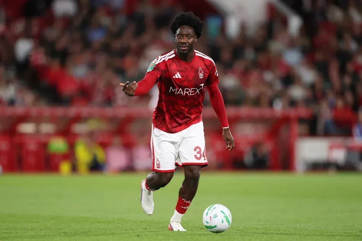 Player in red kit controlling the ball on field Player in red kit controlling the ball on field