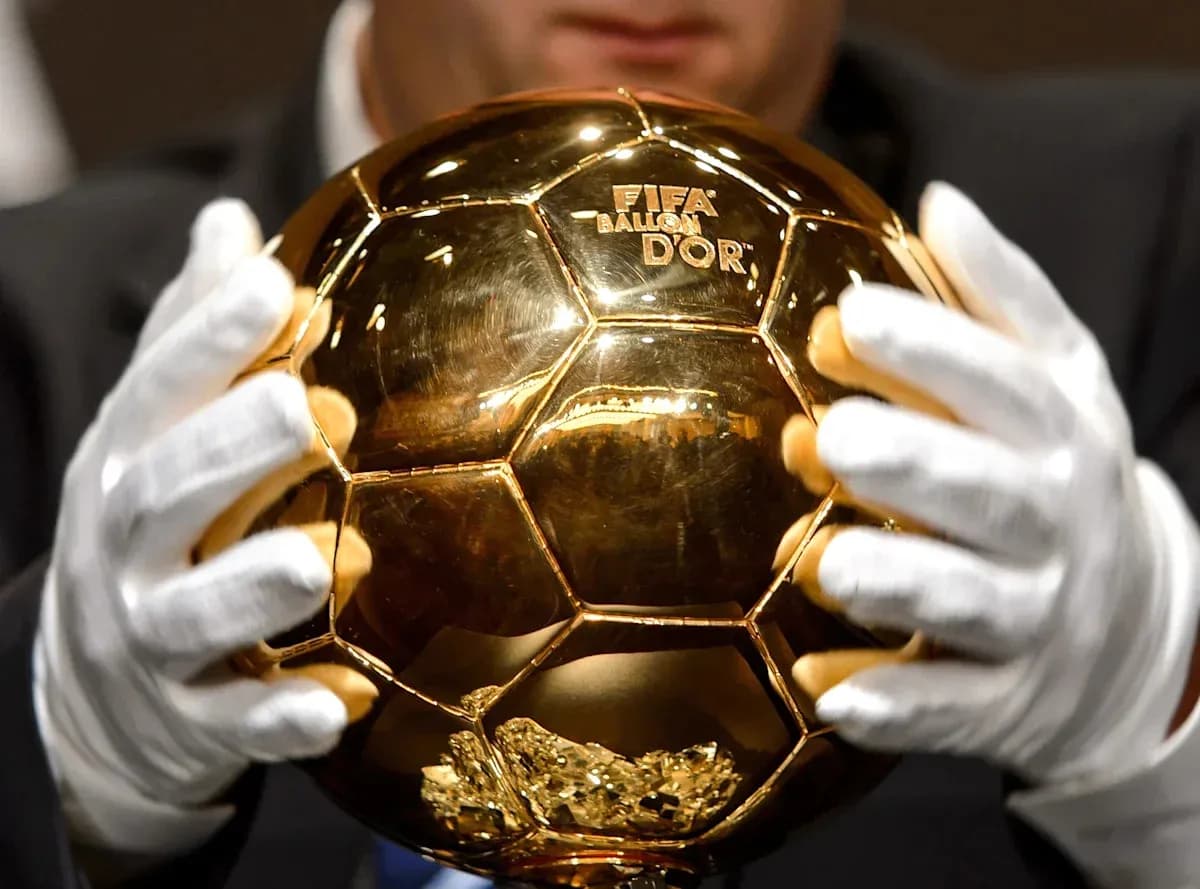 Person holding the FIFA Ballon d'Or trophy Person holding the FIFA Ballon d'Or trophy