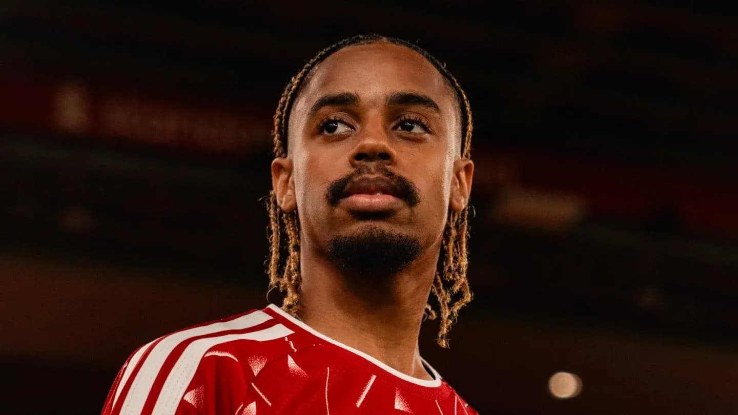 Player wearing red jersey posing at stadium Player wearing red jersey posing at stadium