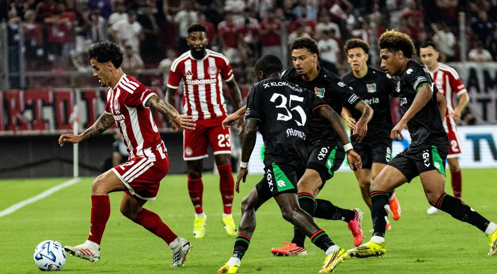 Olympiakos player dribbling against NEC defenders Olympiakos player dribbling against NEC defenders