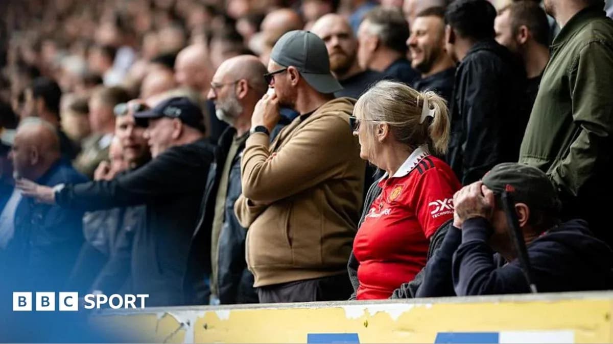 Fans watching the match in the stadium stands Fans watching the match in the stadium stands