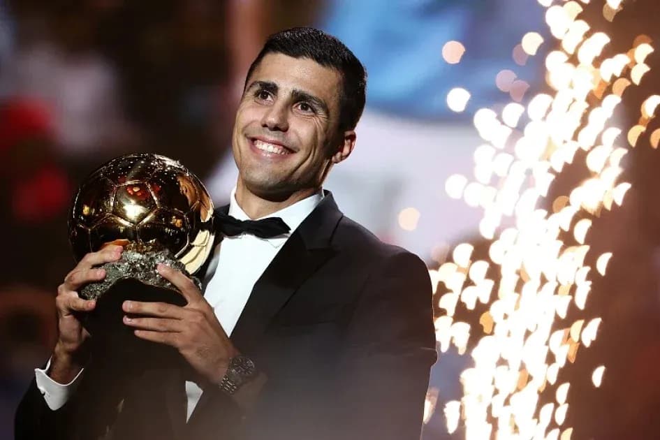 Player holding Ballon d'Or trophy on stage Player holding Ballon d'Or trophy on stage