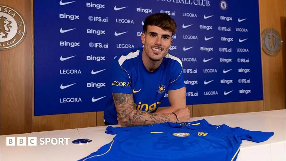Player posing with Chelsea jersey at press conference Player posing with Chelsea jersey at press conference