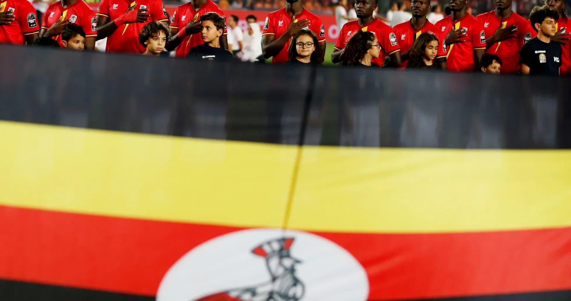 Ugandan team standing for national anthem with flag Ugandan team standing for national anthem with flag
