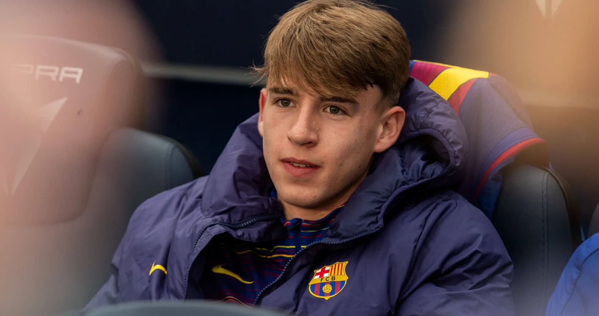 Player seated on bench in Barcelona team jacket Player seated on bench in Barcelona team jacket