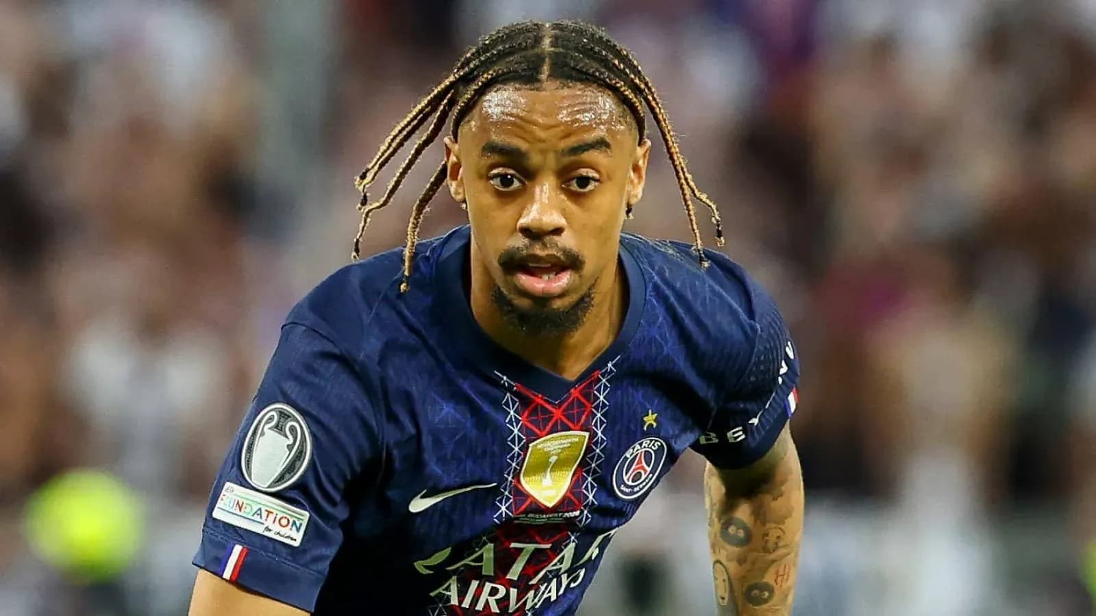 Player in PSG jersey sprinting on the field Player in PSG jersey sprinting on the field