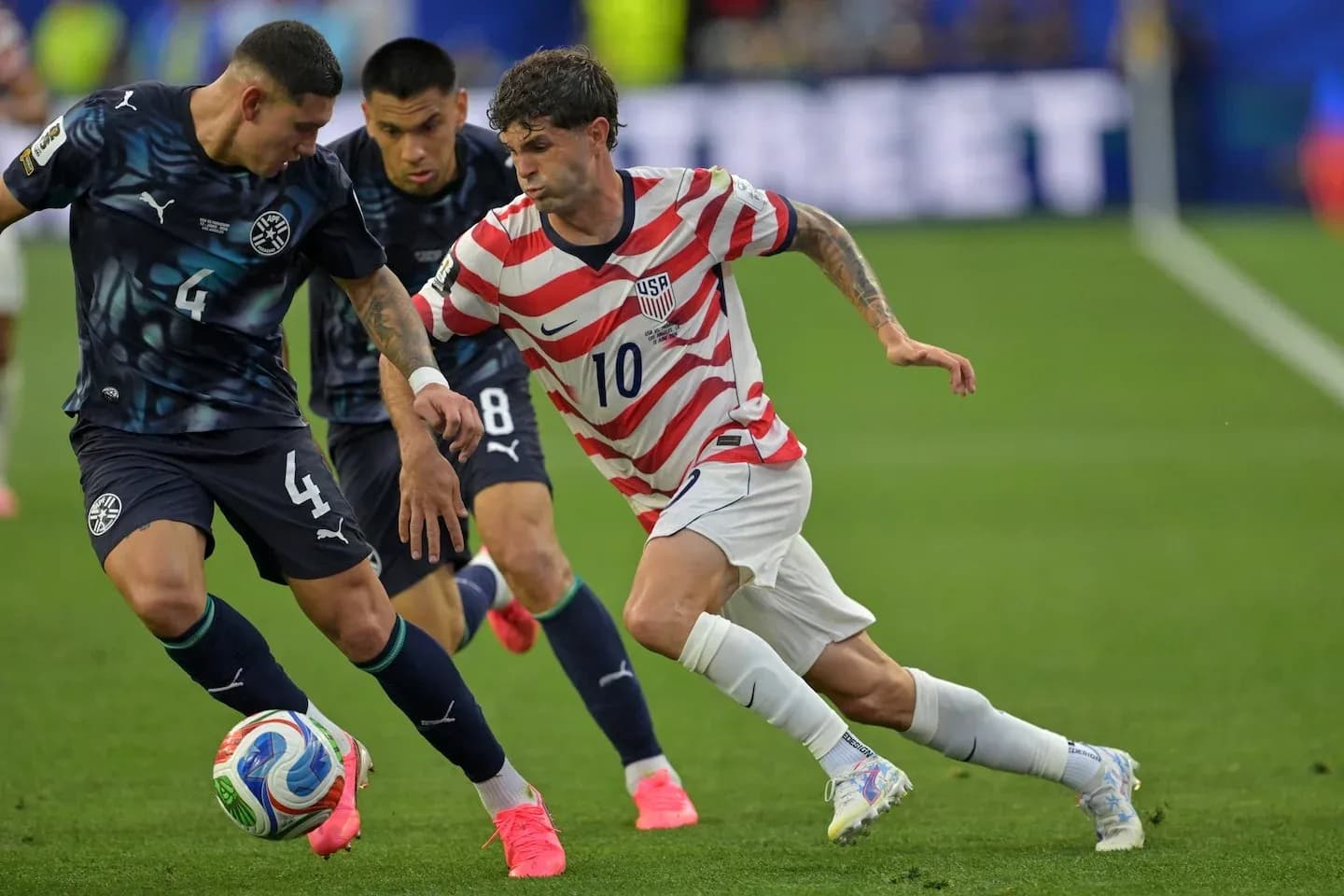 USA player dribbling past Paraguay defenders during match USA player dribbling past Paraguay defenders during match