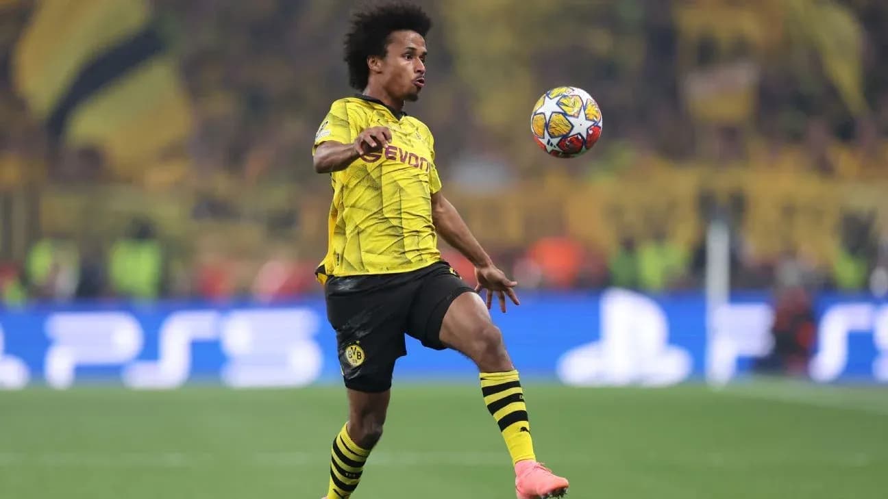 Player in Borussia Dortmund jersey controlling the ball Player in Borussia Dortmund jersey controlling the ball