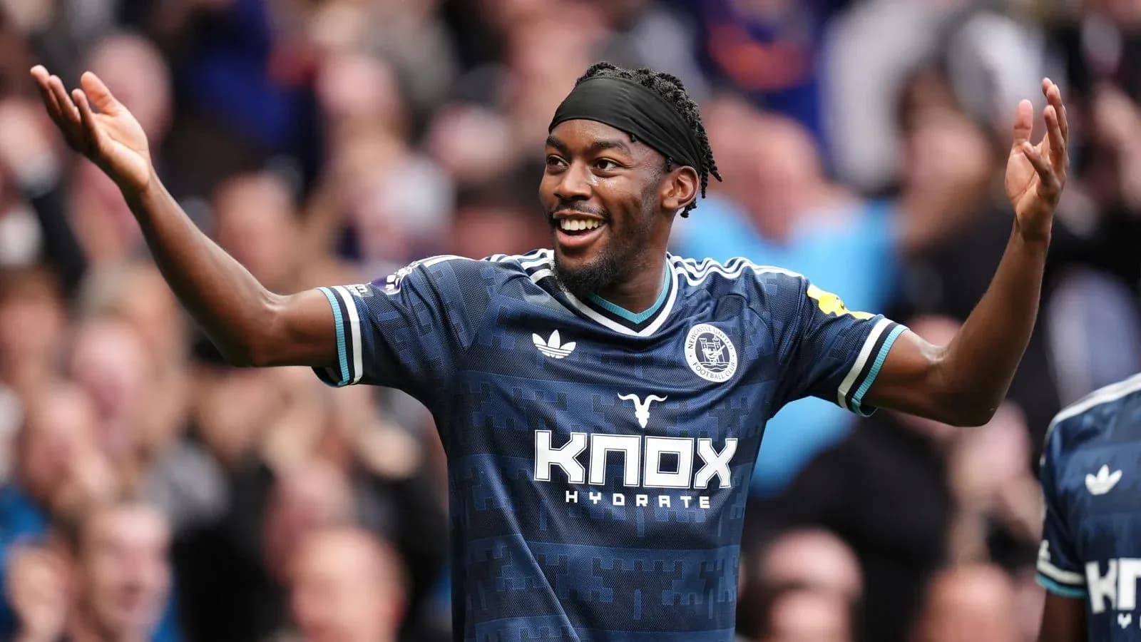 Player celebrating with arms raised during match Player celebrating with arms raised during match