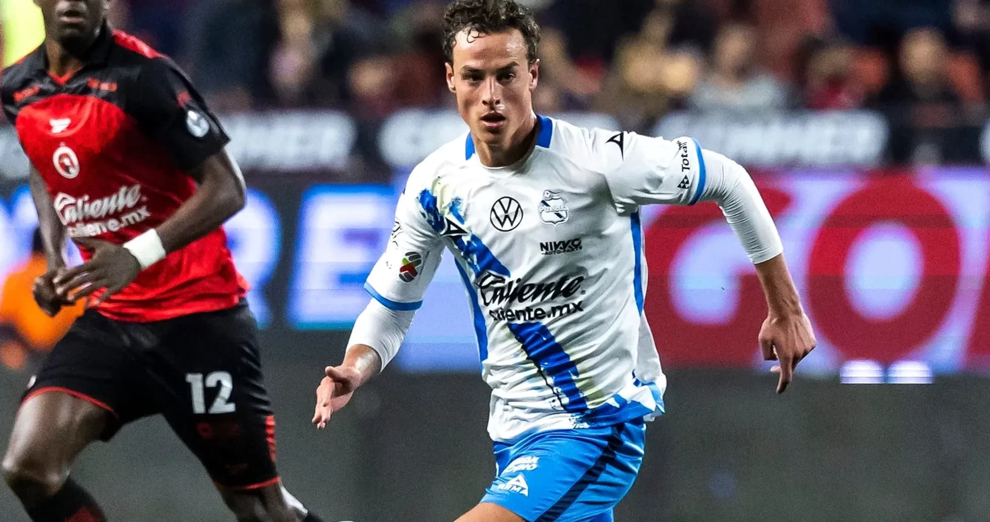 Puebla player dribbling against Club America opponent Puebla player dribbling against Club America opponent