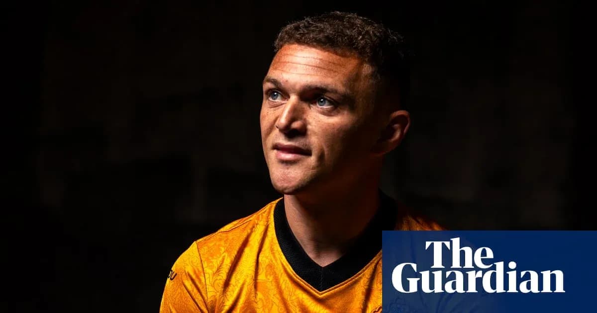 Player in orange jersey looking upwards in dim light Player in orange jersey looking upwards in dim light