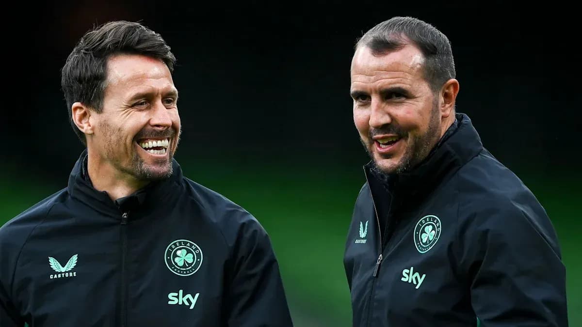 Two coaches smiling and talking during training session Two coaches smiling and talking during training session