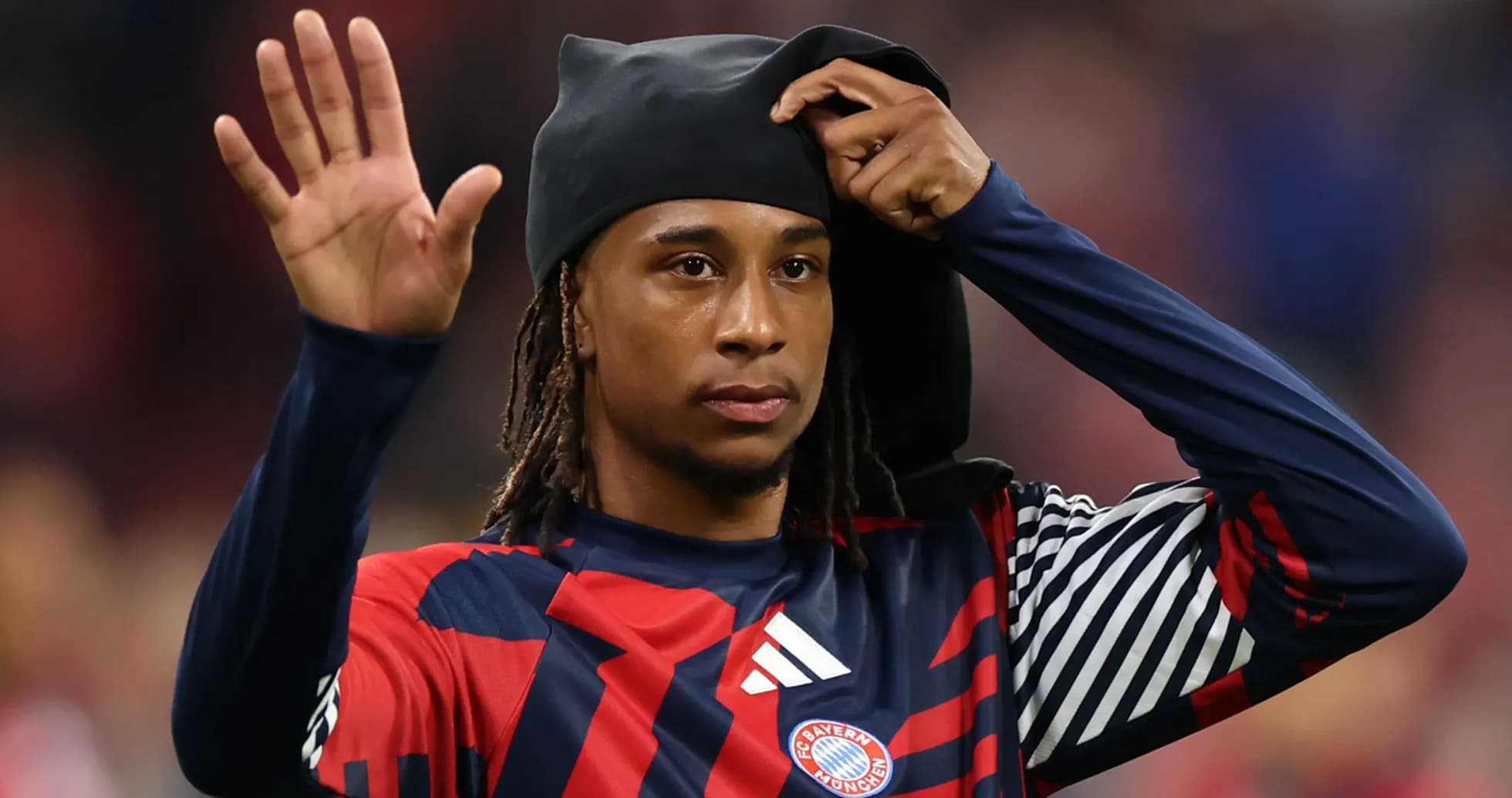 Player waving while putting on a black headwear Player waving while putting on a black headwear