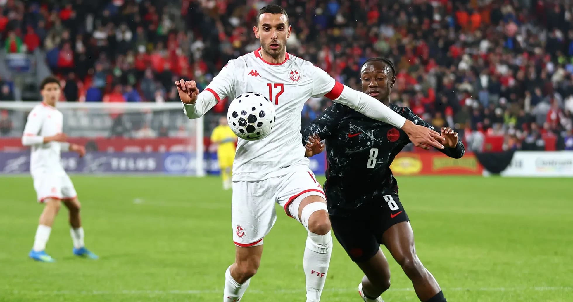 Tunisian player controlling the ball against opponent Tunisian player controlling the ball against opponent