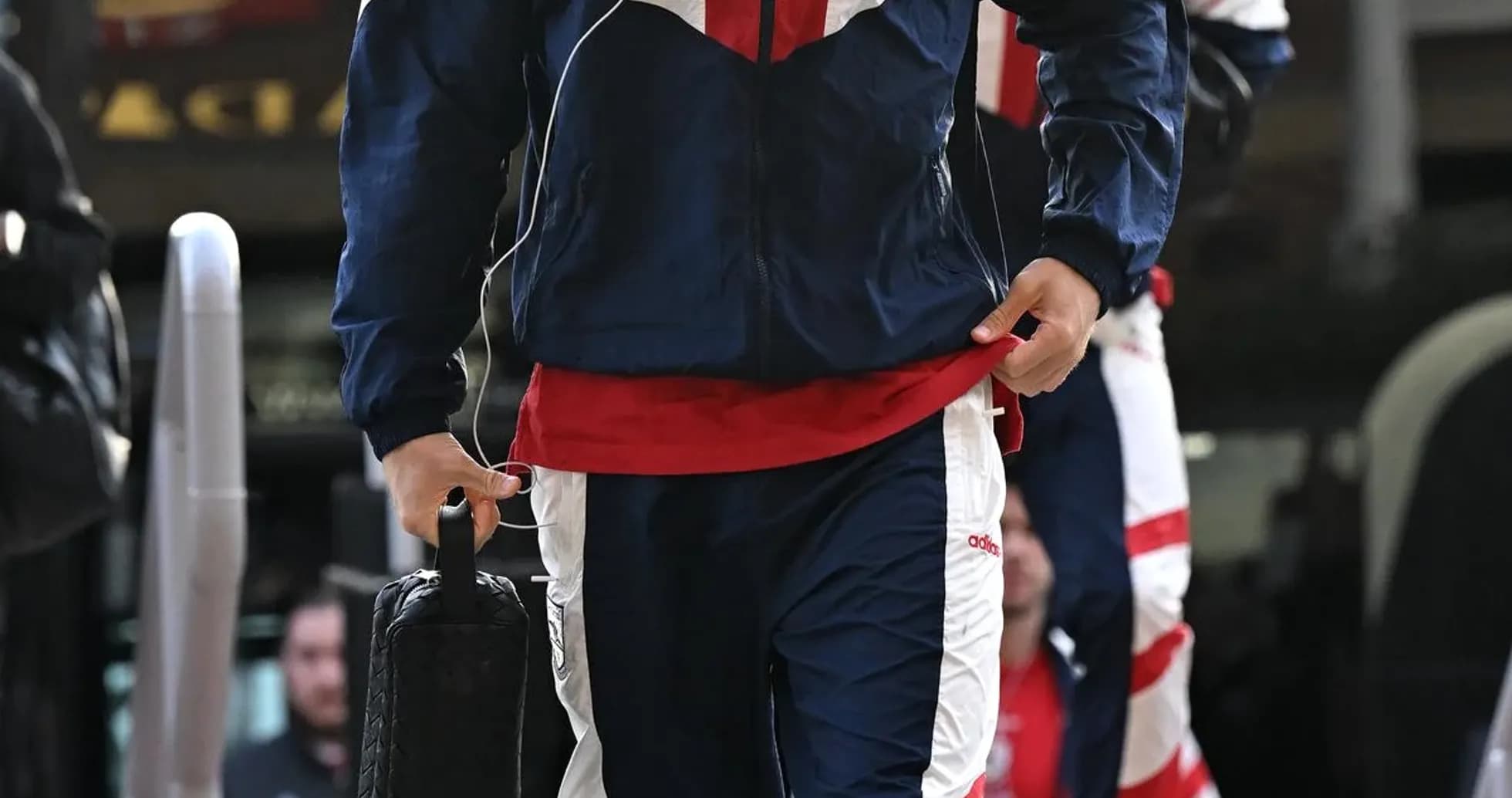 Player in tracksuit arriving at team bus Player in tracksuit arriving at team bus