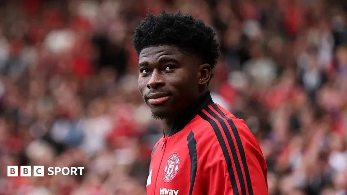 Football player in Manchester United kit on pitch Football player in Manchester United kit on pitch