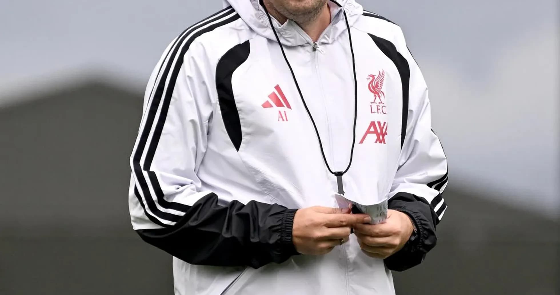 Coach walking on training pitch at Liverpool FC Coach walking on training pitch at Liverpool FC