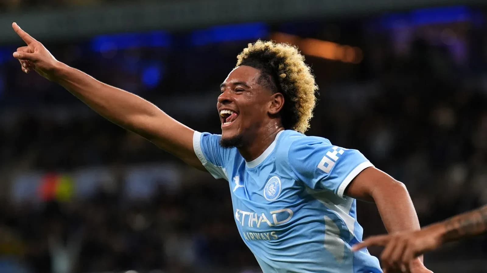 Player celebrating a goal with raised arm Player celebrating a goal with raised arm