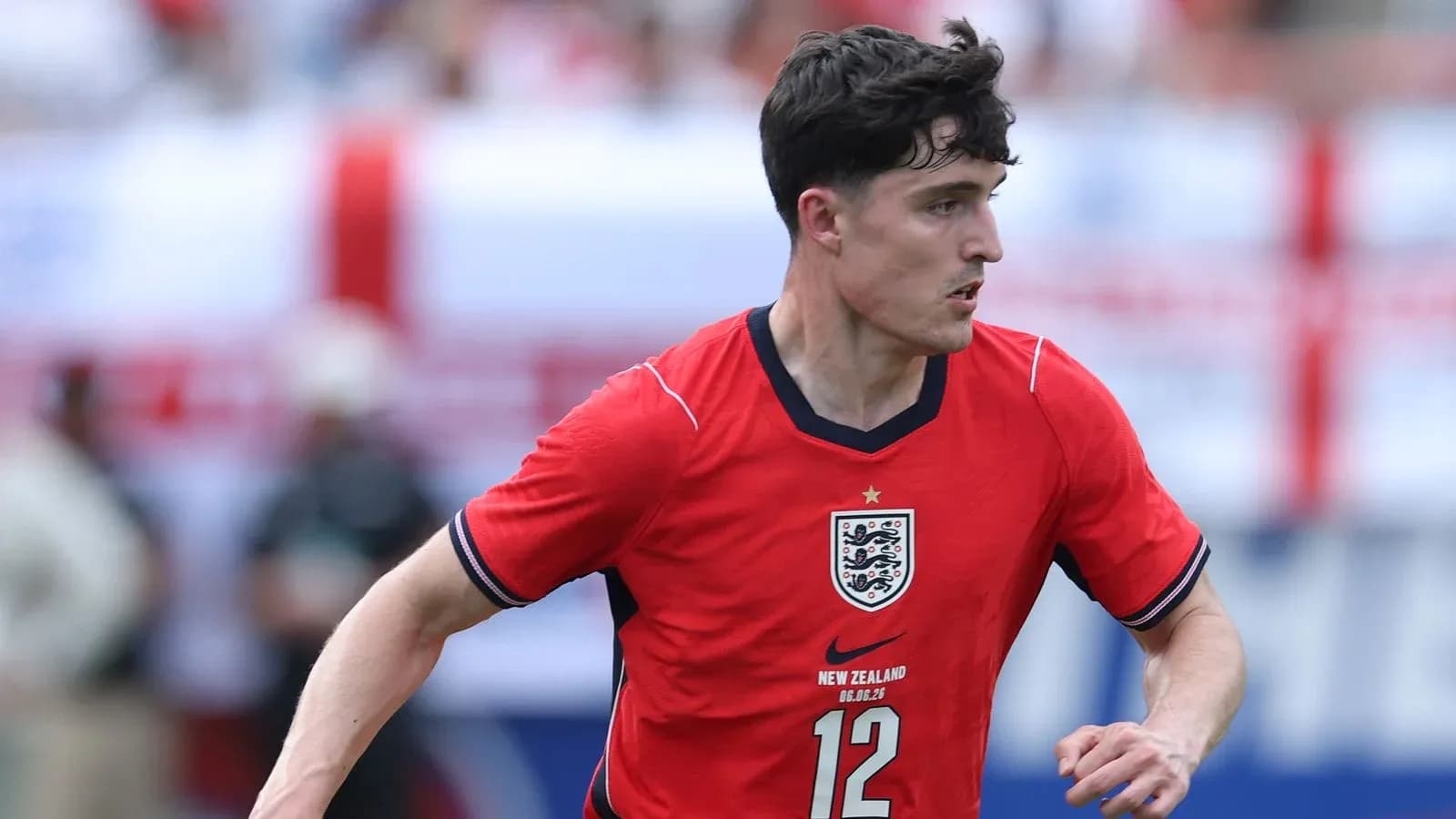 Player in red England kit running on the field Player in red England kit running on the field
