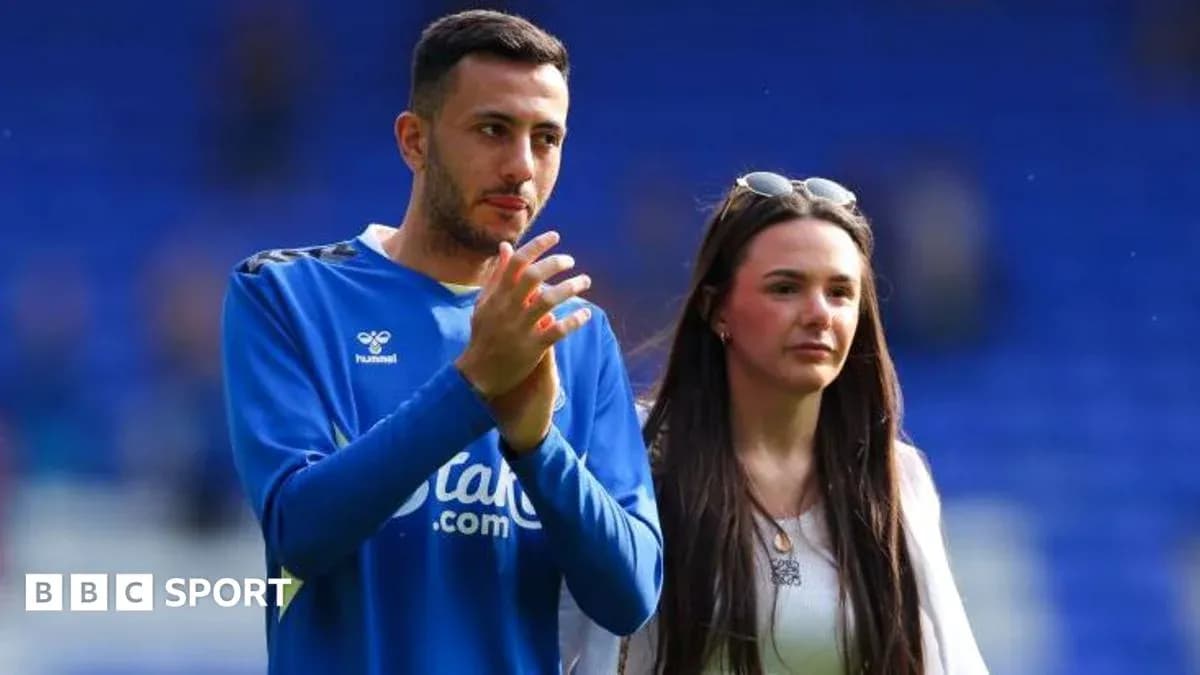 Player and companion walking on the pitch Player and companion walking on the pitch