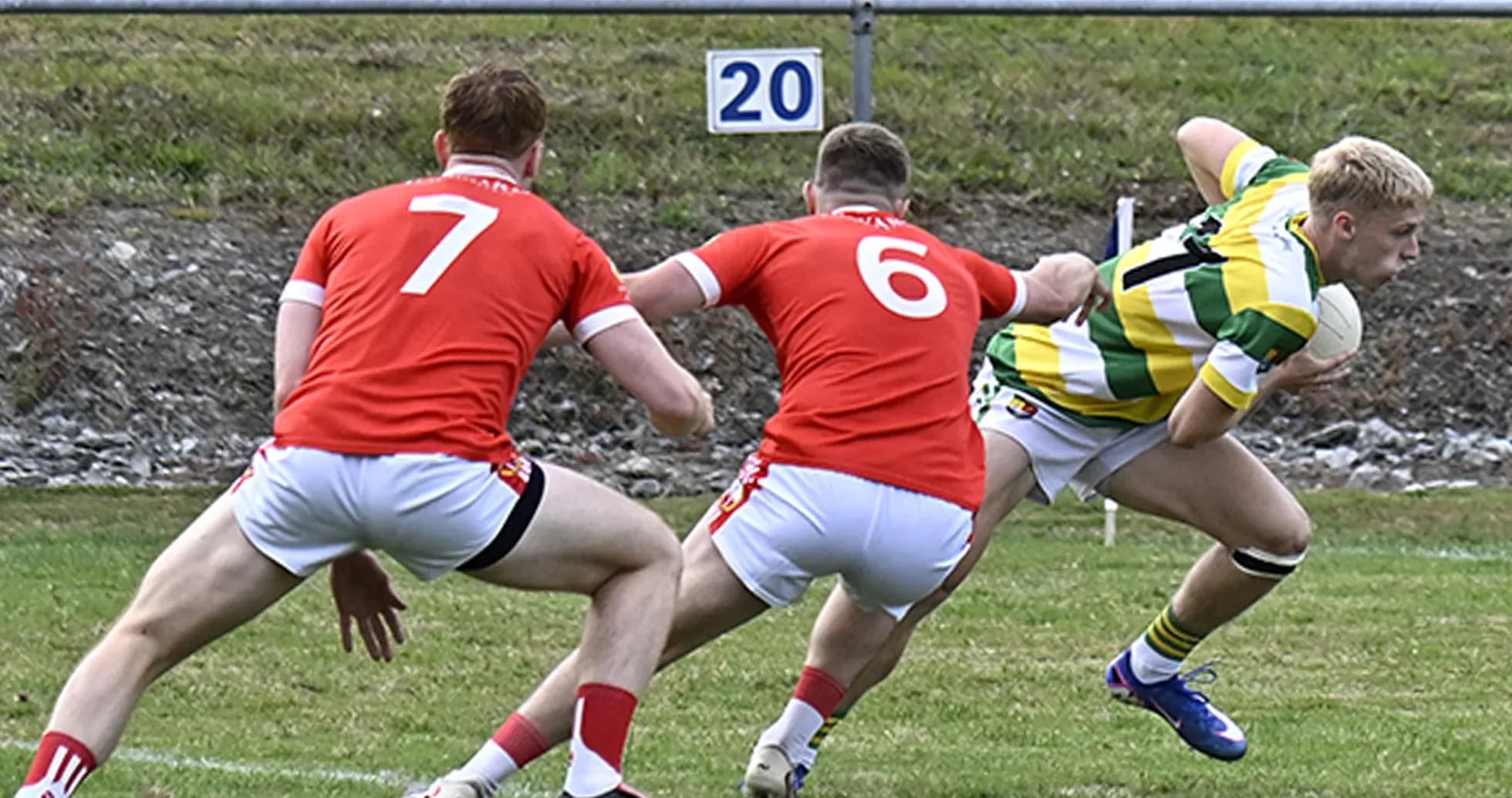 Player in green and yellow evading two defenders Player in green and yellow evading two defenders