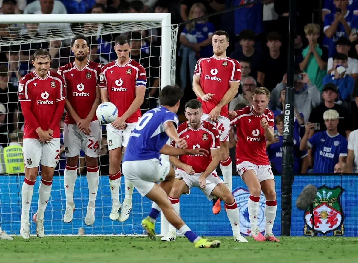 Player taking free kick while defenders form wall Player taking free kick while defenders form wall