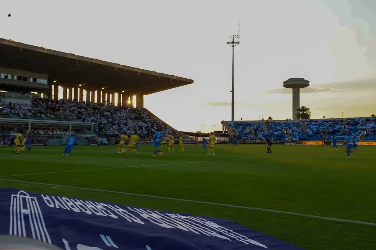 Players in blue and yellow competing during sunset match Players in blue and yellow competing during sunset match