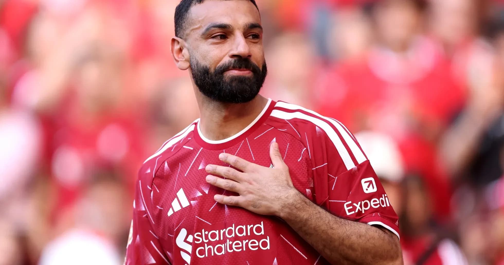 Player in red jersey gestures to crowd Player in red jersey gestures to crowd