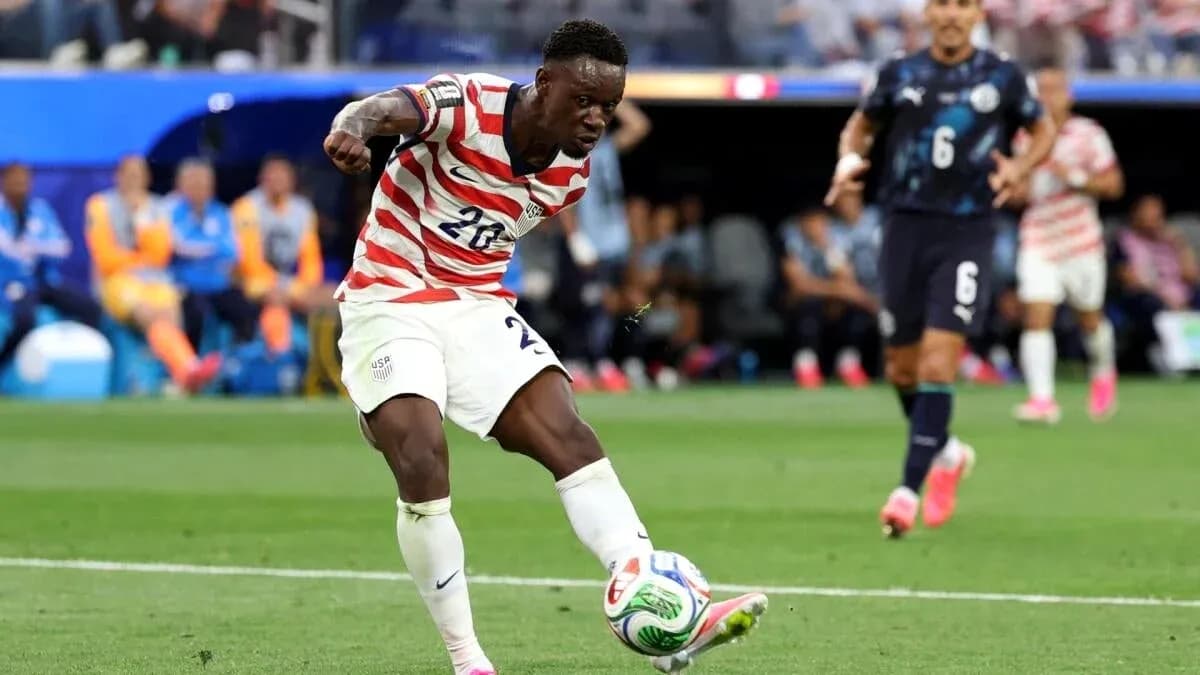 Player in USA kit kicking soccer ball during match Player in USA kit kicking soccer ball during match