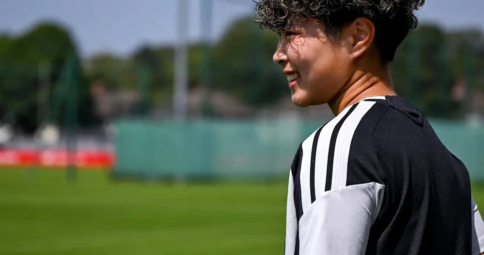 Player walking on training pitch in sunlight Player walking on training pitch in sunlight