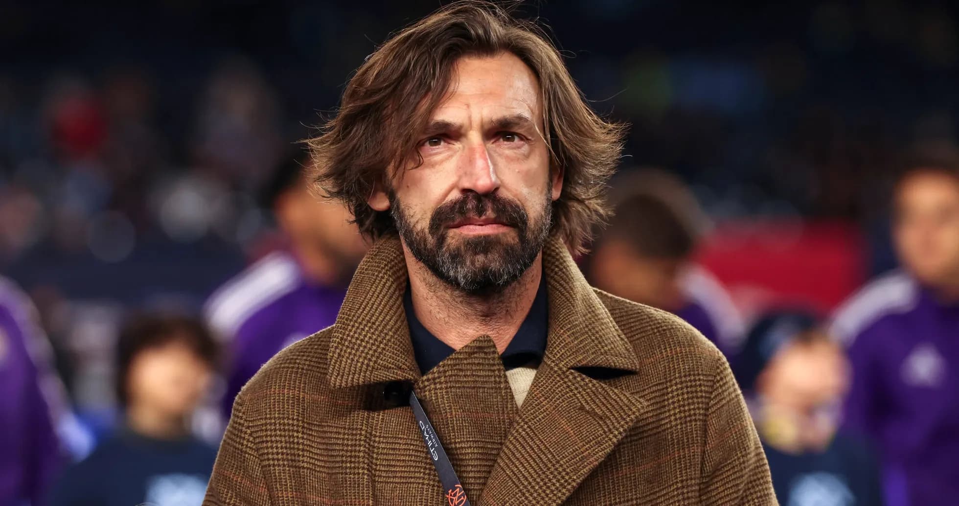 Man in brown coat standing on the sidelines Man in brown coat standing on the sidelines