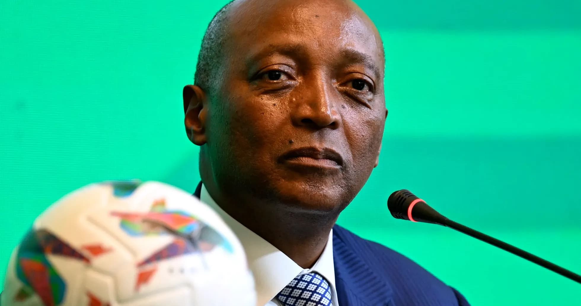 Official speaking at a press conference with football Official speaking at a press conference with football