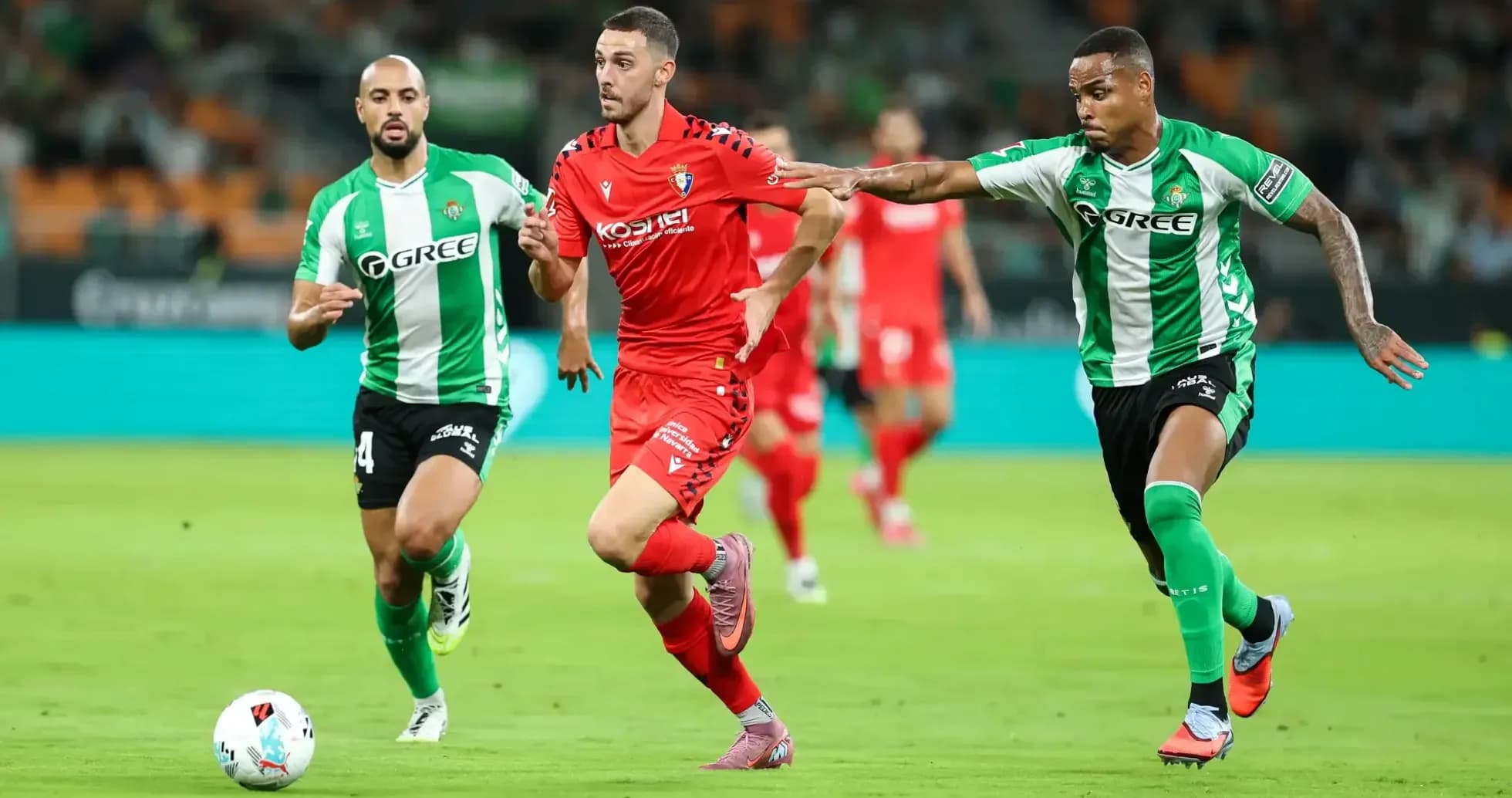 Osasuna player dribbling past Real Betis defenders Osasuna player dribbling past Real Betis defenders