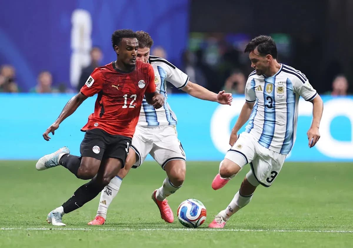Egyptian player dribbling past two Argentine defenders Egyptian player dribbling past two Argentine defenders