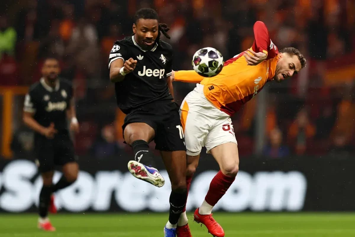 Player kicking ball while opponent falls during match Player kicking ball while opponent falls during match