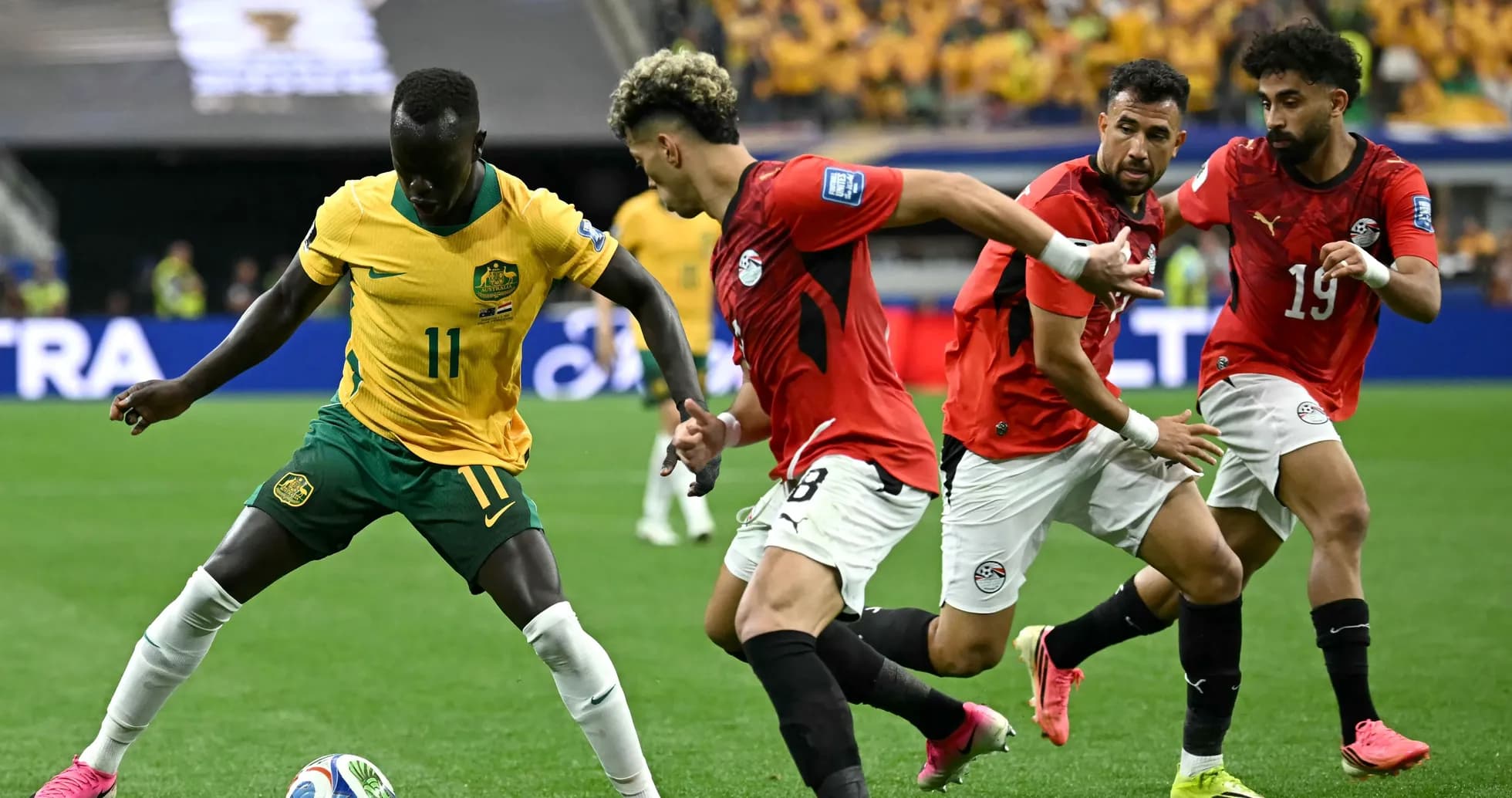 Australian player dribbling past Egyptian defenders during match Australian player dribbling past Egyptian defenders during match
