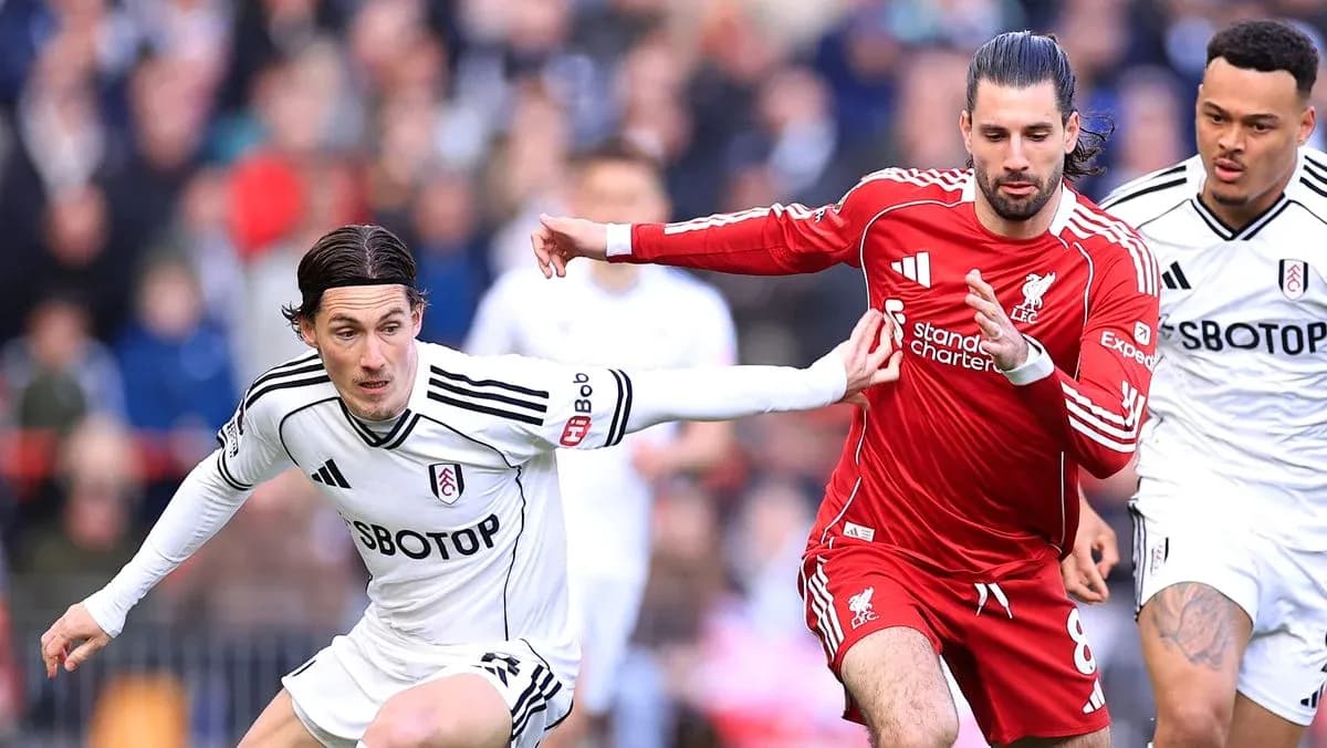 Players from Fulham and Liverpool competing for the ball Players from Fulham and Liverpool competing for the ball