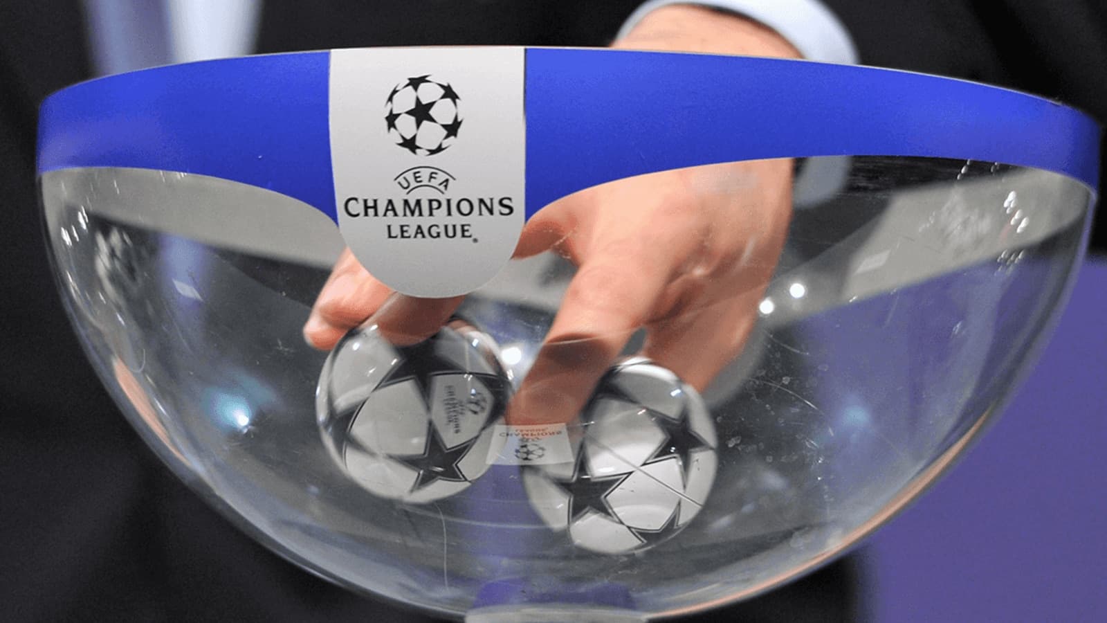 Hand reaching into UEFA Champions League draw bowl Hand reaching into UEFA Champions League draw bowl