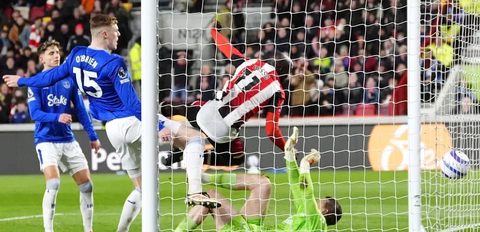 Brentford player scoring against Everton goalkeeper Brentford player scoring against Everton goalkeeper