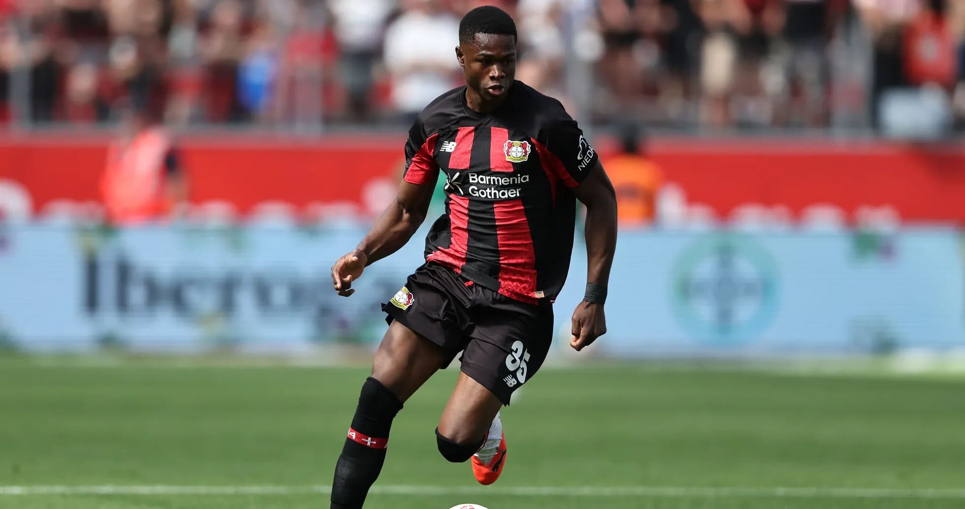 Player in Bayer Leverkusen kit dribbling the ball Player in Bayer Leverkusen kit dribbling the ball
