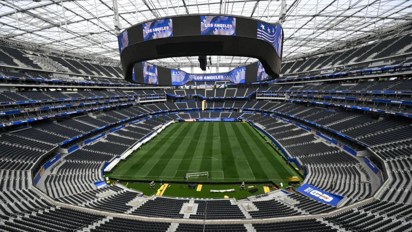 Empty stadium with field and large screens overhead Empty stadium with field and large screens overhead